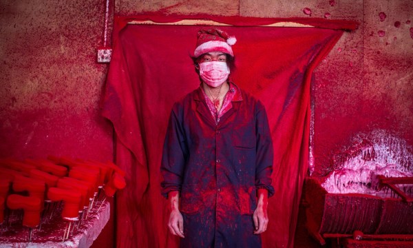 Mandatory Credit: Photo by Imaginechina/REX (4301626b) 19-year-old worker Wei wearing a face mask and a Christmas hat covered in red powder Christmas decorations being made at a factory in Yiwu city, Zhejiang province, China - 15 Dec 2014 The city of Yiwu is known as China?s massive Christmas market. From 2001 till now, the booming Christmas production industry there has grown from a mere 10 factories to more than 600. The village produces 60 percent of the world's Christmas decorations. 19-year-old factory worker Wei says he knows that Christmas is a festival, but doesn't really know what it's about. Wei and his parents came to Yiwu from their home province after their friends told them that they could make up to 4,000 RMB a month working in the factories. Wei and his father spend 10 hours in this factory every day producing plastic snowflakes for about 3,000 RMB per month. Red powder used as colouring hovers in the air, and the two get through about 10 face masks a da. Although he wears a Christmas hat at work, Wei?s father doesn't intend on celebrating the holiday. The hat protects his hair from the red dust which covers them from head to toe like soot after several hours of work.